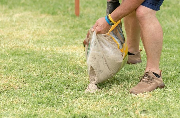 Bunnings team member adding sand on the lawn