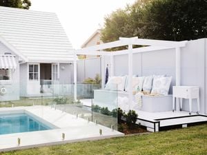 Swimming pool and outdoor room with white decking and raised platform