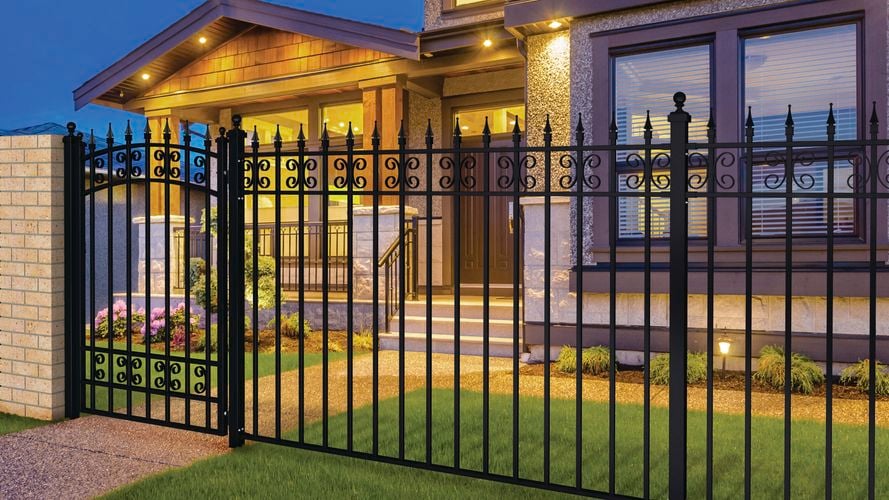 Steel gate and fence installed in front of brown two-story house