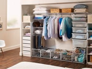 An organised wardrobe with hanging clothes, boxes and storage space