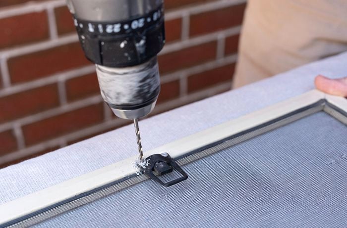 A person is removing the clip completely to access the spline using a drill.