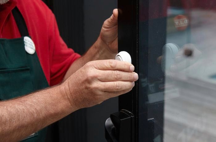Person attaching lock device to door.