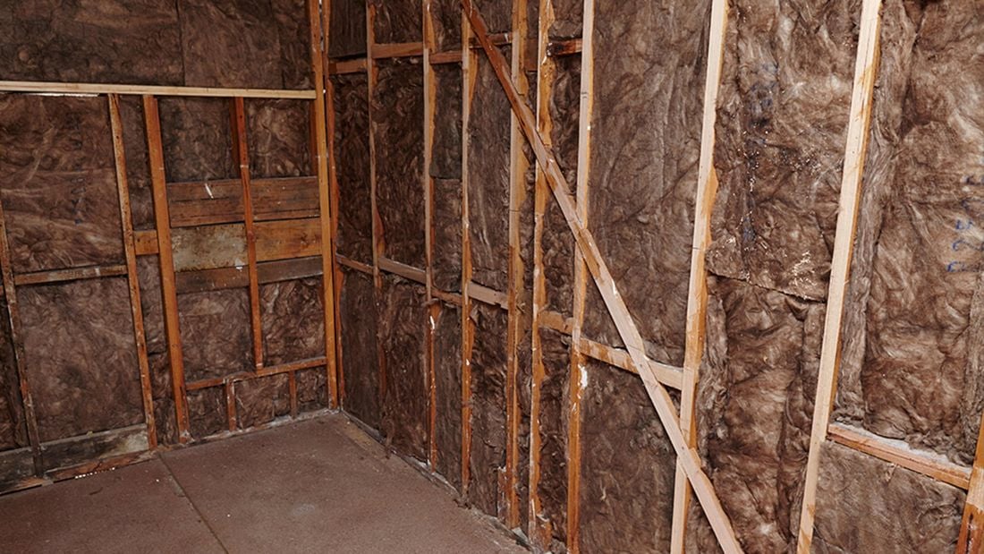 An indoor room with bare walls lined with insulation
