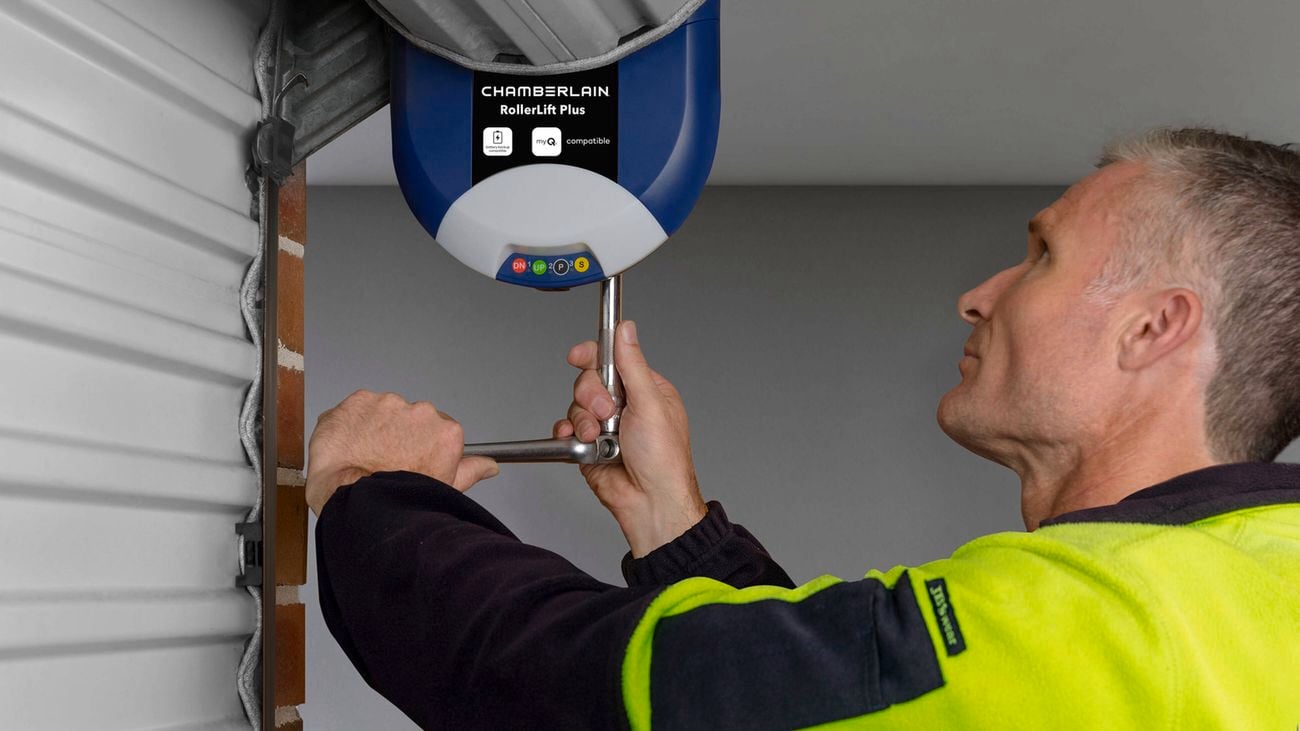 Person opening a garage of a modern house with a garage remote.