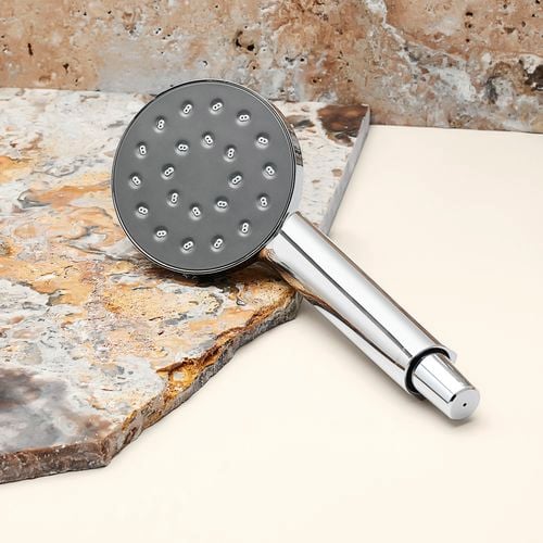 Chrome shower head styled with a neutral granite backdrop