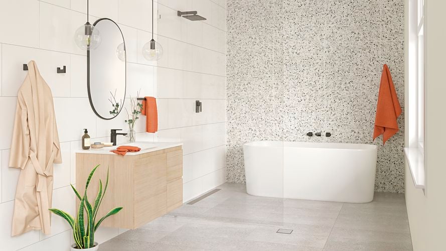 Bathroom with timber vanity, grey tiles and white bathtub.