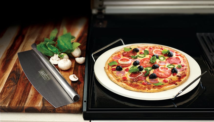 Homemade pizza resting on a stone pizza cooker