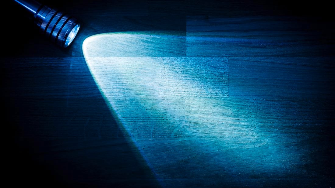 Lamp shining light on a desk.