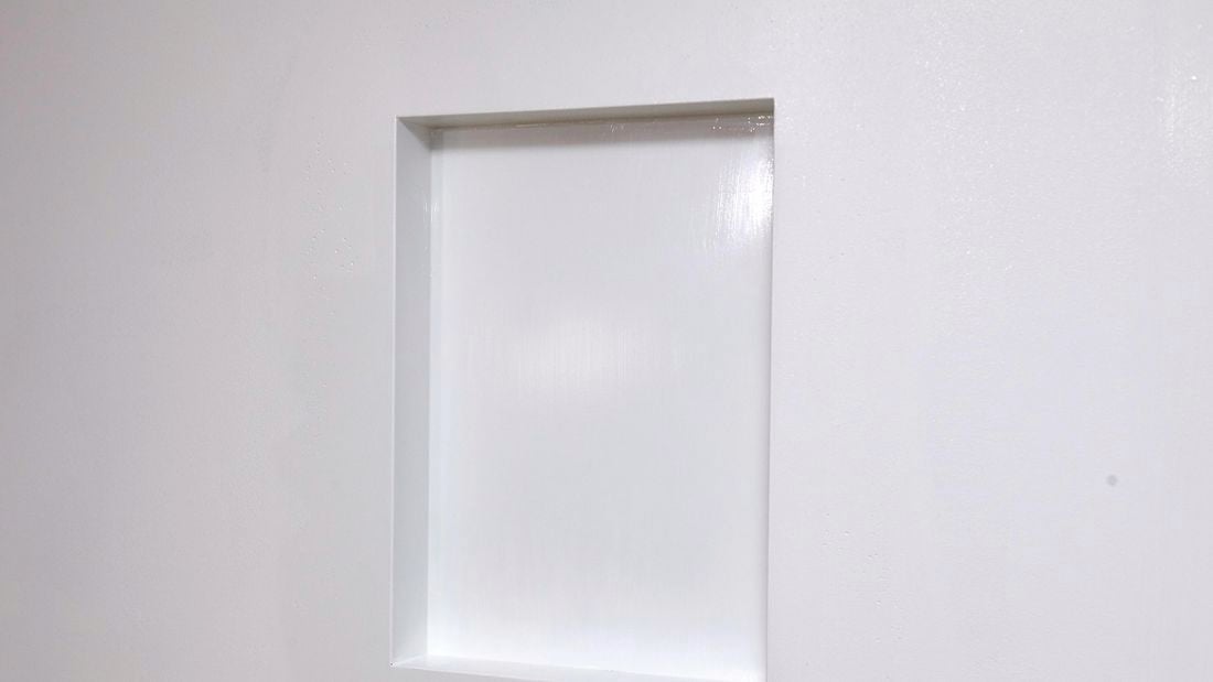 A rectangular niche in a white wall