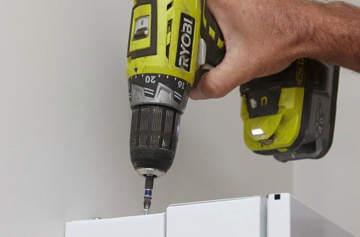 Using the drill and screws to secure the panels.
