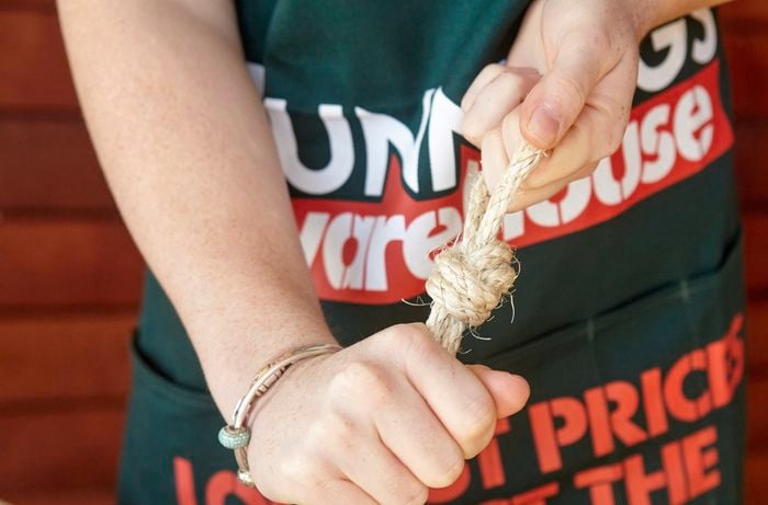 A person tying a knot in a piece of rope