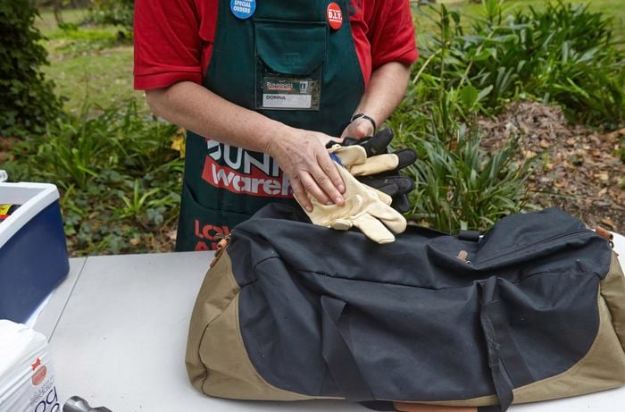 Heavy duty gloves going into a sports bag