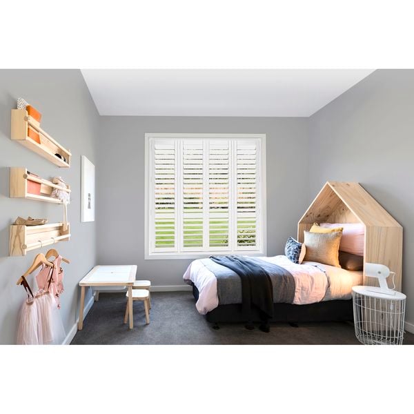 Kids bedroom with bed and white venetian blinds.