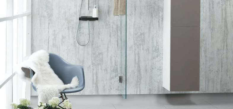 A bathroom with large, stone-look wall panels and a chair