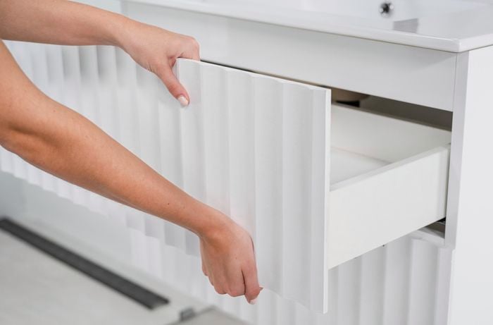 A scallop panel attached to a drawer being slid into the vanity