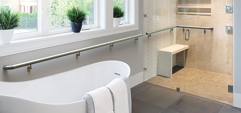 A modern bathroom with metal handrail beside bath and in the shower