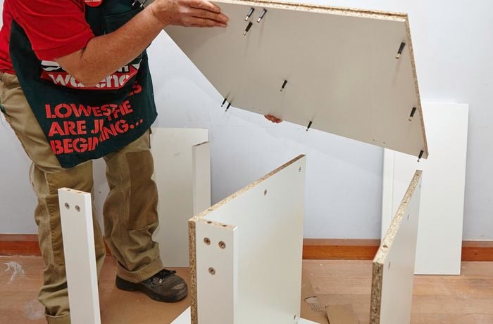 Person attaching side panels to rails