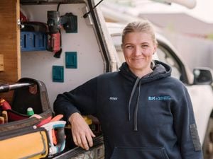 A smiling Women In Apprenticeships Awards winner 2025 Renee Evans stands beside her work ute.