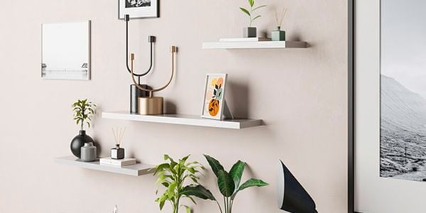Floating shelves on a wall with frames and ornaments.