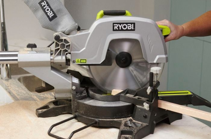 Person using circular saw to cut quad moulding to size.