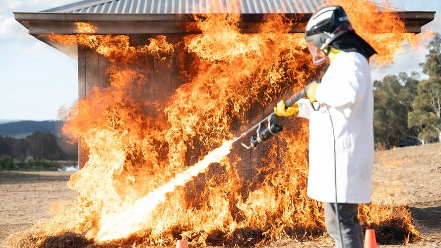 Flames hitting small structure, testing FIRECOAT.