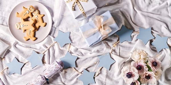 MDF light blue star garland with presents and gingerbread men on a tablecloth
