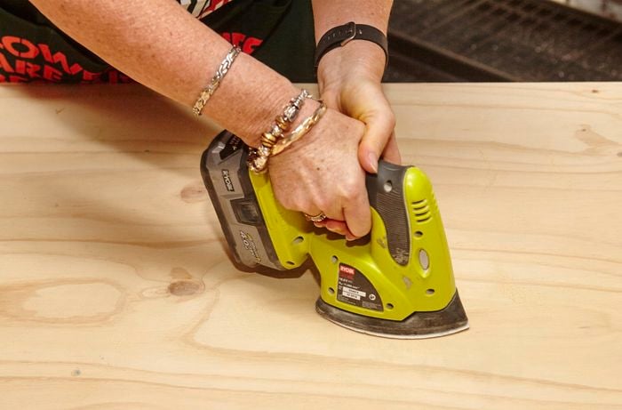 A power sander being used to sand a surface of timber by a Bunnings team member