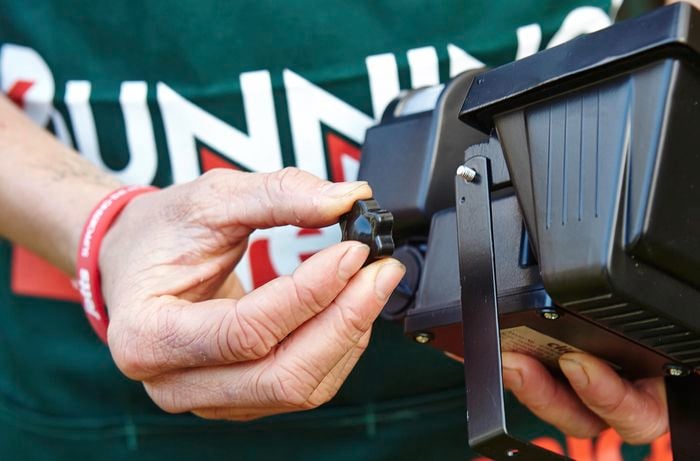 A person removing the mounting bracket from a sensor light