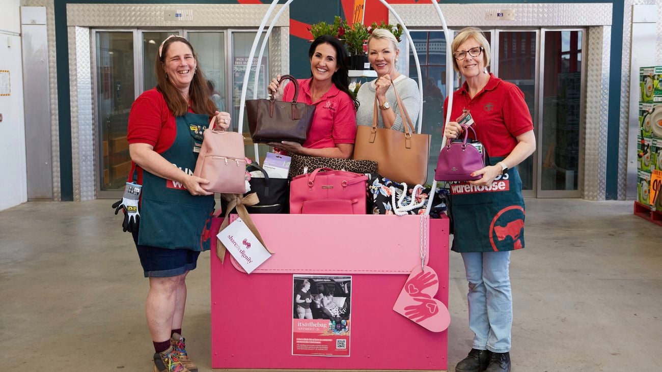 In store image of team members and customers beside the share the dignity donation display