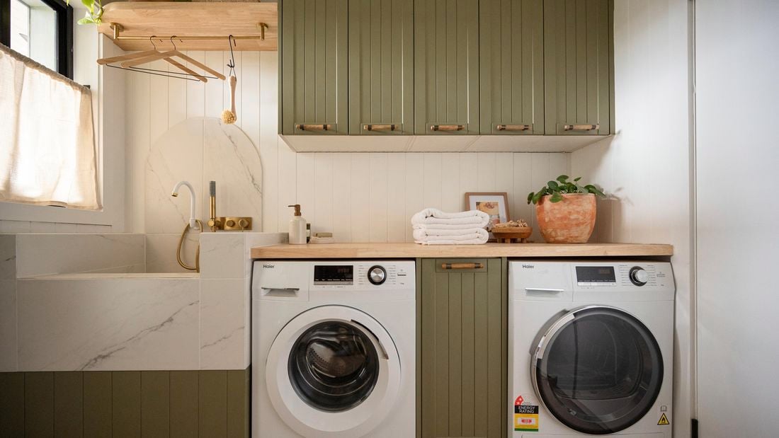 A modern laundry room featuring a front-loading washing machine and a matching dryer placed side-by-side.
