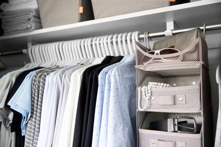 Wardrobe with many clothes hangers and hanging accessories organiser
