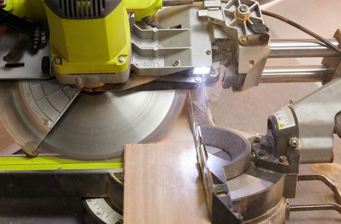 Person cutting timber on angle using circular saw