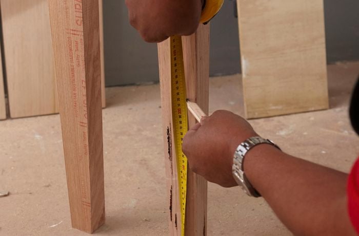Person measuring length of table leg
