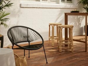 Outdoor chair with rattan stools & bar table in a backyard