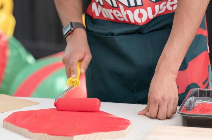 Using paint roller to paint timber red
