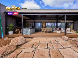 Back of a house with an outdoor setting, lounge and kitchen on decking.