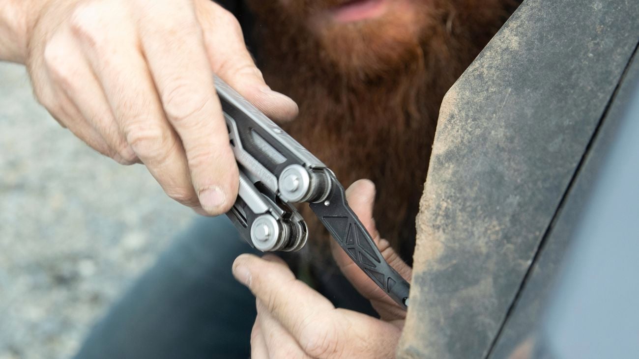 Person holding a Gerber Dual-Force using the bit driver function on a car