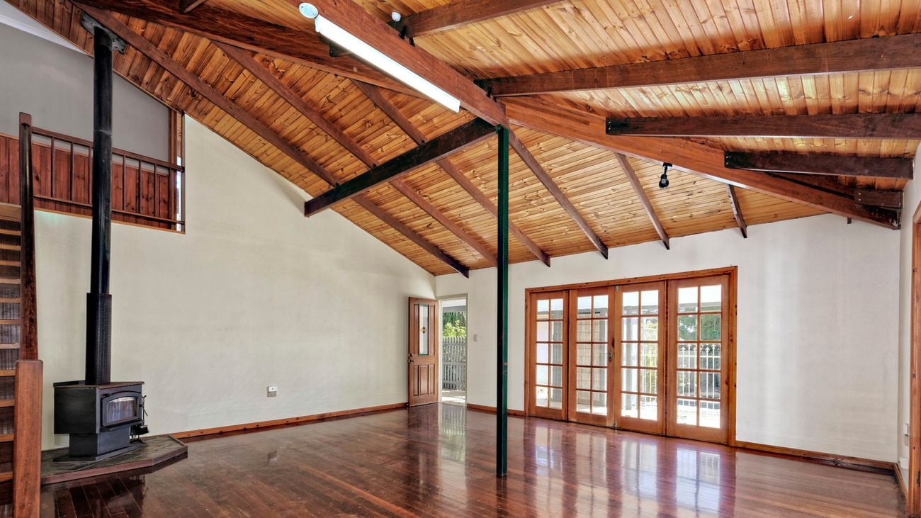 Empty home with fireplace and wooden floors.