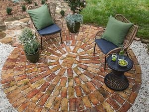 A completed brick paved patio complete with two lounge chairs