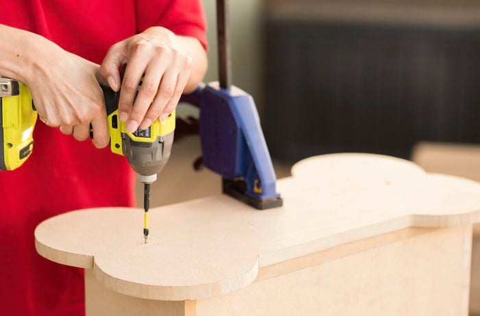 Drilling holes in a bone shaped MDF board.