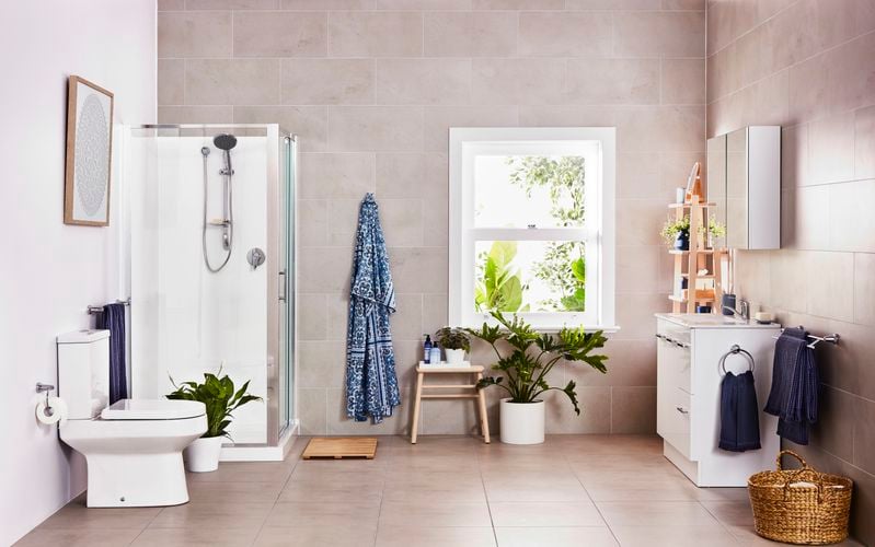 Tiled bathroom with shower, toilet and white cabinet with built-in sink