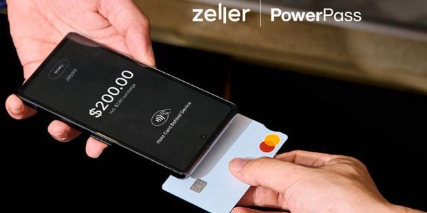 A person holding a card to a smart phone to make payment