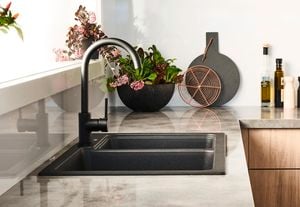 Kitchen with black sink and black tap.
