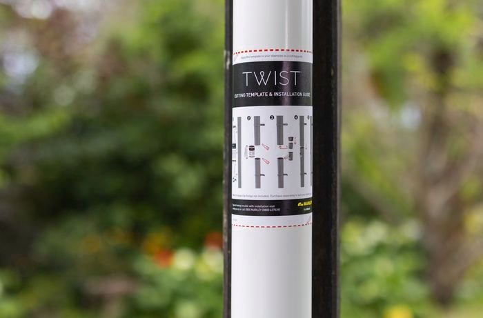 A white pole with instructions of how to cut it.