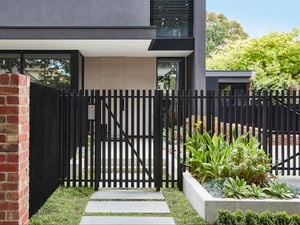 red brick house with black metal fence