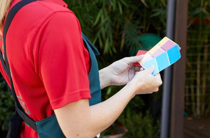 A woman holding paint swatches