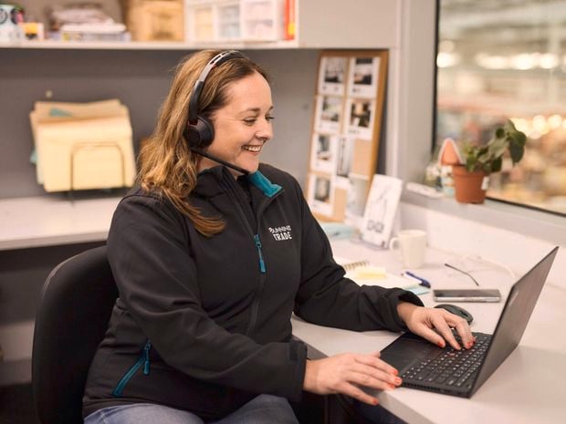 A Bunnings Team Member sitting at a desk with a laptop in front of them.