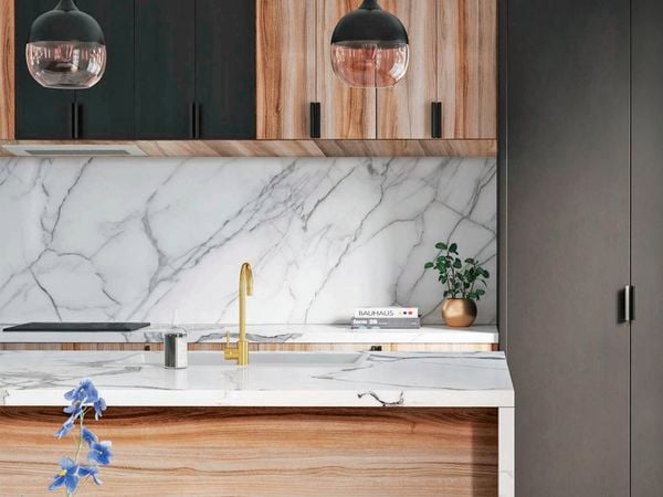 Close up of Kaboodle marble-look kitchen benchtop, sink and brushed brass sink mixer