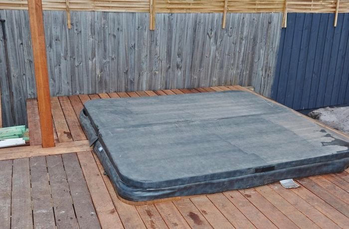 Outdoor decking area with spa that has a cover on it.