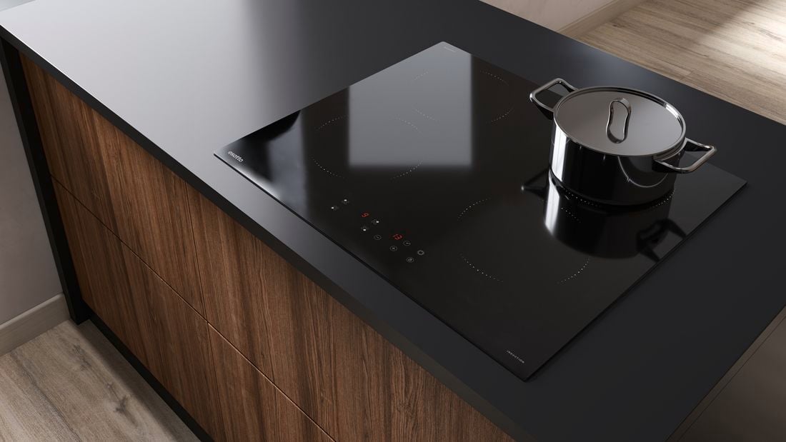 Black stove top with pot, on a black benchtop with dark brown wood-look drawers